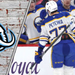 JJ Peterka celebrating a goal with the Utah Mammoth logo to the left of the image