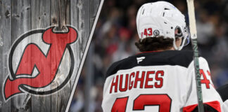 New Jersey Devils defenseman Luke Hughes skating with the puck during an NHL game.
