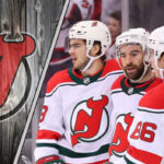 New Jersey Devils star Jack Hughes skates with the puck during an NHL game.