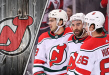 New Jersey Devils star Jack Hughes skates with the puck during an NHL game.