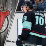 Seattle Kraken forward celebrating a goal with the New Jersey Devils logo to the left as NHL trade rumors swirl around him