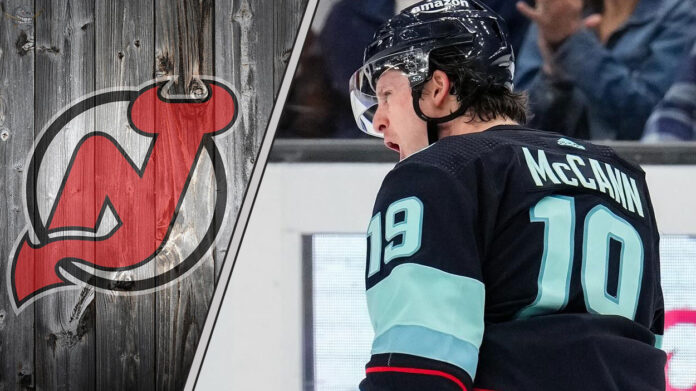 Seattle Kraken forward Jaren McCann celebrating a goal during a game with the New Jersey Devils logo to the left as NHL trade rumors swirl around him