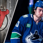 Vancouver Canucks captain Quinn Hughes looking upset on the ice, amidst swirling NHL trade rumors
