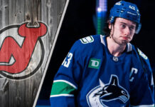 Vancouver Canucks captain Quinn Hughes looking upset on the ice, amidst swirling NHL trade rumors