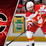 The Silence is Deafening: What’s Really Going on with Rasmus Andersson and the Flames? Rasmus Andersson skating with the puck wondering about the latest NHL trade rumors involving him