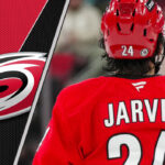 Seth Jarvis Point Projections 2025-26: The Fantasy Hockey Whisperer’s Take Seth Jarvis, forward for the Carolina Hurricanes, skates with the puck during a game. He is wearing a red Hurricanes jersey with the number 24. The background is blurred, showing the ice and boards of a hockey arena. He is poised for a breakout season according to fantasy hockey projections.