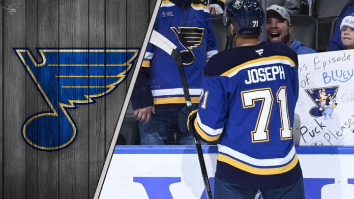 St. Louis Blues forward Mathieu Joseph talking to his teammates, symbolizing the internal competition for roster spots amidst NHL trade rumors