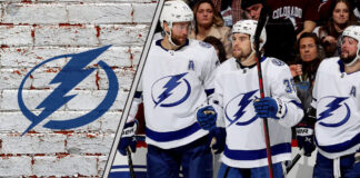 The Tampa Bay Lightning team celebrating a goal on the ice, with the crowd cheering in the background.