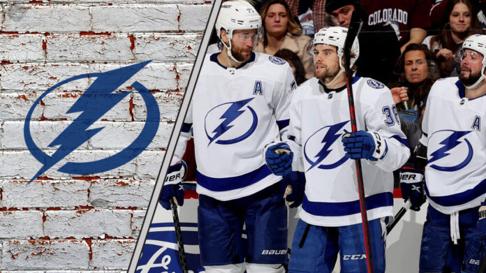 The Tampa Bay Lightning team celebrating a goal on the ice, with the crowd cheering in the background.