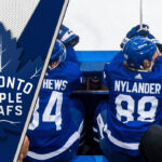 Toronto Maple Leafs forwards sit on the bench looking intense during an NHL game, representing the team's new physical identity