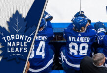 Toronto Maple Leafs forwards sit on the bench looking intense during an NHL game, representing the team's new physical identity