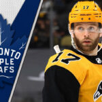 Pittsburgh Penguins forward Bryan Rust look on during an NHL game, with a focus on the ongoing NHL trade rumors surrounding him.