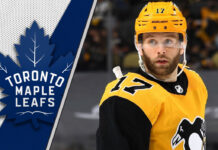 Pittsburgh Penguins forward Bryan Rust look on during an NHL game, with a focus on the ongoing NHL trade rumors surrounding him.