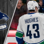 Vancouver Canucks captain Quinn Hughes looks on during a game, representing the focus of current NHL trade rumors