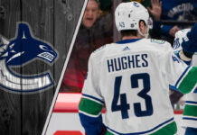 Vancouver Canucks captain Quinn Hughes looks on during a game, representing the focus of current NHL trade rumors