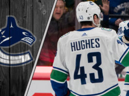 Vancouver Canucks captain Quinn Hughes looks on during a game, representing the focus of current NHL trade rumors