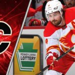 Calgary Flames defenseman Rasmus Andersson skates with the puck during an NHL game, focused on the play amidst swirling NHL trade rumors about his contract.