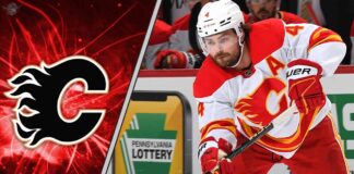 Calgary Flames defenseman Rasmus Andersson skates with the puck during an NHL game, focused on the play amidst swirling NHL trade rumors about his contract.