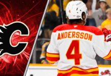 Calgary Flames defenseman Rasmus Andersson looks on during an NHL game, as NHL trade rumors swirl about his future with the team.