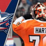 Goaltender Carter Hart in his Philadelphia Flyers jersey, looking focused during a game, as he's rumored to be signing with the Columbus Blue Jackets.