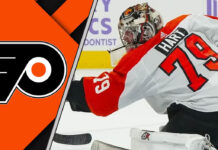 Carter Hart in a Philadelphia Flyers jersey, making a save in a packed arena.