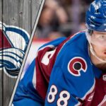 Colorado Avalanche center Martin Necas skating during a game, looking focused. The background shows the crowd and arena lights.