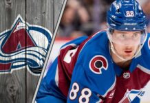 Colorado Avalanche center Martin Necas skating during a game, looking focused. The background shows the crowd and arena lights.