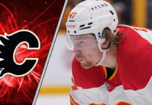 Calgary Flames forward Connor Zary skates with the puck during an NHL game, focused on the play.