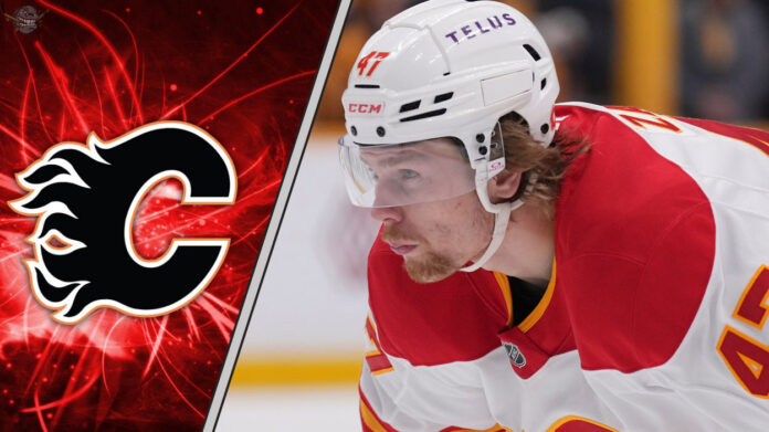 Calgary Flames forward Connor Zary skates with the puck during an NHL game, focused on the play.