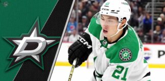 Dallas Stars forward Jason Robertson skates with the puck during an NHL game, with the Dallas Stars logo in the background.