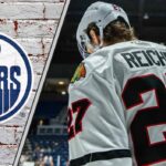 Chicago Blackhawks forward Lukas Reichel skates with his head down thinking about the latest NHL trade rumors about him