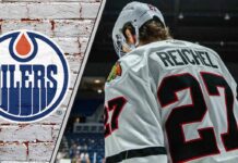 Chicago Blackhawks forward Lukas Reichel skates with his head down thinking about the latest NHL trade rumors about him