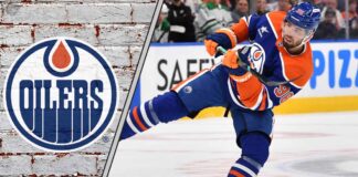 Edmonton Oilers defenseman Jake Walman skating with the puck during an NHL game.
