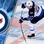 Winnipeg Jets defenseman Josh Morrissey skating with the puck during an NHL game, quarterbacking the power play.