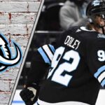 Logan Cooley #92 of the Utah Mammoth skates with the puck during a game, poised for a breakout 2025-26 NHL season with projected 77 points