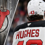 New Jersey Devils defenseman Luke Hughes skating during an NHL game, looking focused on the play.