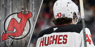 New Jersey Devils defenseman Luke Hughes skating during an NHL game, looking focused on the play.