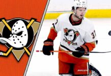 Anaheim Ducks center Mason McTavish skates with the puck during an NHL game, with the Ducks logo visible on his jersey.