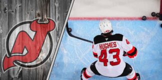 New Jersey Devils defenseman Luke Hughes skates with the puck during an NHL game, with a focus on his future contract negotiations.