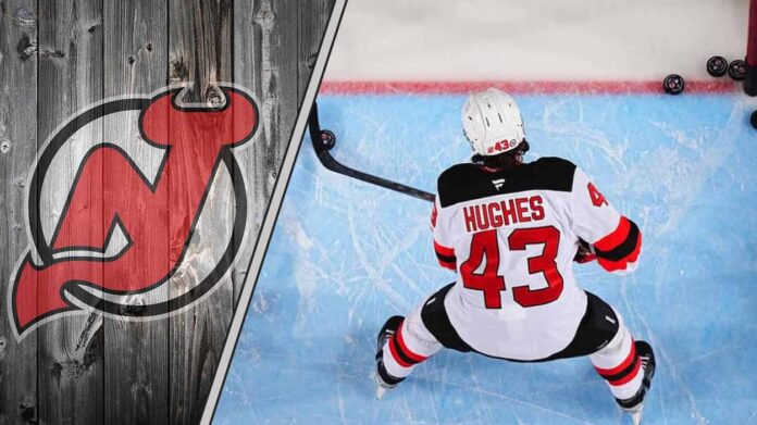 new-jersey-devils-luke-hughes-contract-negotiations New Jersey Devils defenseman Luke Hughes skates with the puck during an NHL game, with a focus on his future contract negotiations.