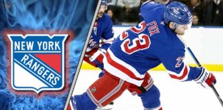 New York Rangers defenseman Adam Fox skating with the puck during an NHL game, looking to make a pass.
