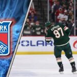 The NY Rangers Russian Revolution: Could Kirill Kaprizov Be the Missing Piece? Kirill Kaprizov in his Minnesota Wild jersey with the New York Rangers logo to the left as NHL trade rumors swirl around him