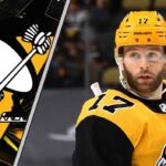 Is a Bryan Rust Trade Inevitable for the Pittsburgh Penguins? Pittsburgh Penguins forward Bryan Rust skates with the puck during an NHL game, with trade rumors swirling about his future with the team.