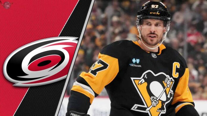 Pittsburgh Penguins captain Sidney Crosby looks on thoughtfully during a game, with the Carolina Hurricanes logo faintly in the background.