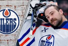 Edmonton Oilers goalie Stuart Skinner standing in his goal crease with his goalie mask off thinking about his next contract