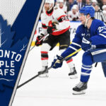 Toronto Maple Leafs defenseman Brandon Carlo skates during an NHL game, representing a key trade chip for the team's forward hunt.