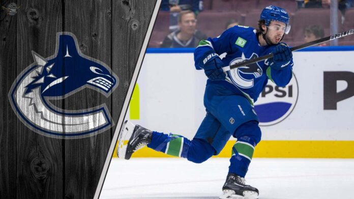 vancouver-canucks-captain-quinn-hughes-in-action Vancouver Canucks captain Quinn Hughes skating during an NHL game, looking focused on the play