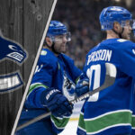 Vancouver Canucks Elias Pettersson celebrates a goal with teammates during an NHL game, focused and determined.