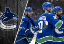 Vancouver Canucks Elias Pettersson celebrates a goal with teammates during an NHL game, focused and determined.