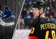 Vancouver Canucks forward Elias Pettersson skates with the puck during an NHL game, focused and determined.
